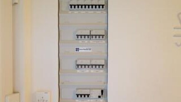 Un tablero eléctrico fijado a la pared, con varios interruptores y enchufes.