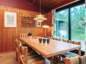 A wooden-paneled room with a long table, chairs, and a window with a view of trees. - Charming Holiday Home in BlÃ¥vand with Hot Tub (Blavand)