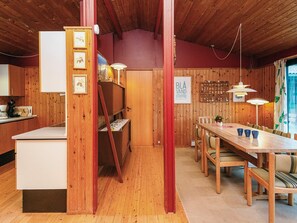 A wooden interior with a dining area, kitchen, and a sign reading "BLA VAND DANMARK". - Charming Holiday Home in BlÃ¥vand with Hot Tub (Blavand)