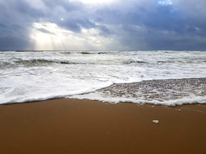 A beach with waves, a cloudy sky, and a visible horizon. - Charming Holiday Home in BlÃ¥vand with Hot Tub (Blavand)