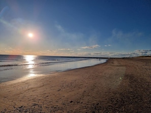 A beach with a clear sky and the sun low on the horizon. - Charming Holiday Home in BlÃ¥vand with Hot Tub (Blavand)