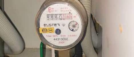 A water meter with a label indicating it is from Elster, model number 44313050, and the year 2004.