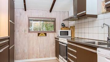 A compact kitchen with a microwave, oven, and sink.
