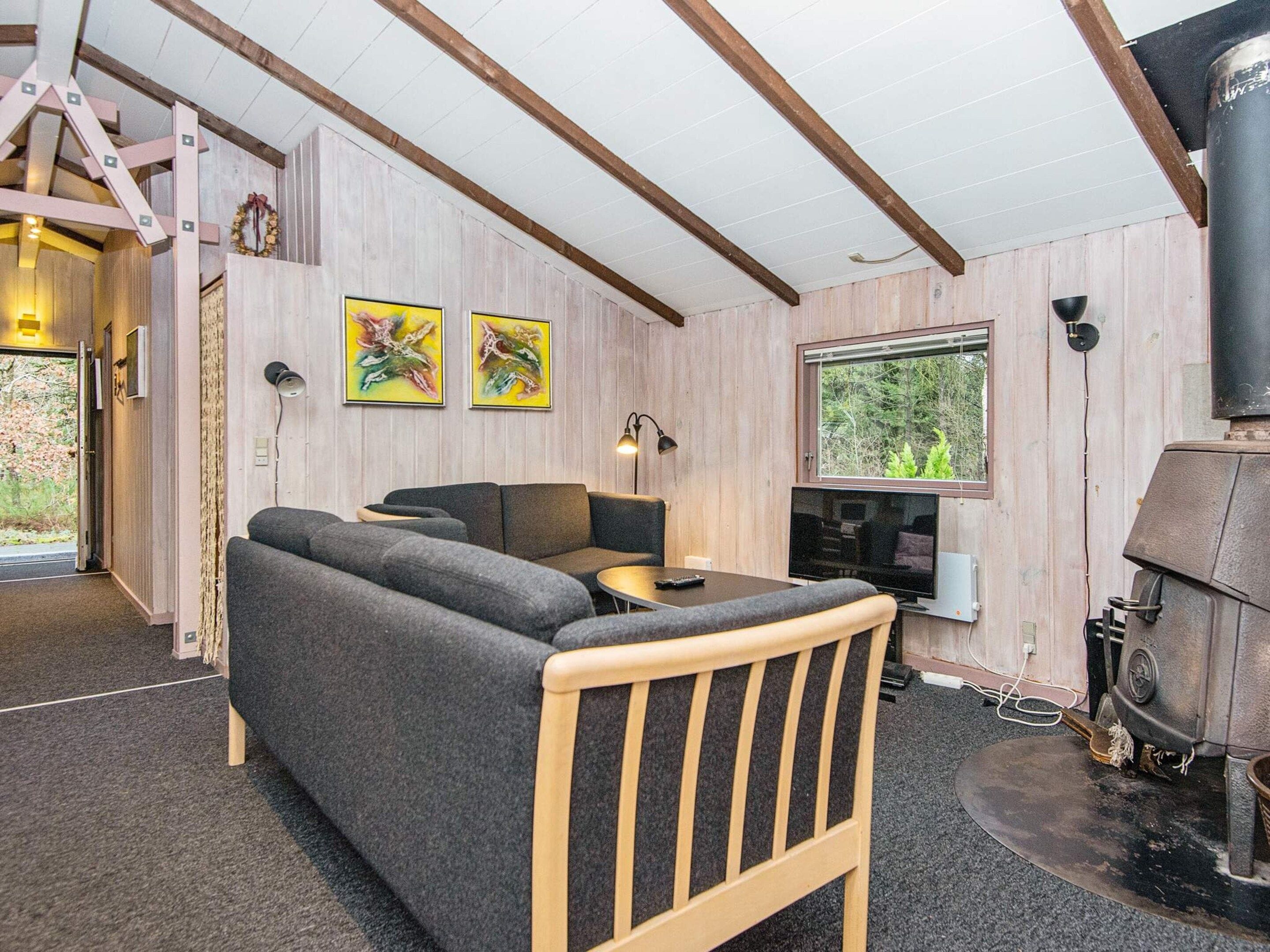 A cozy room with a sofa, a small table, a television, and a fireplace.