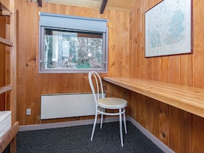A room with wooden walls, a window with a view of trees, a white chair, and a map on the wall. - 5 Person Holiday Home in Herning (Herning)