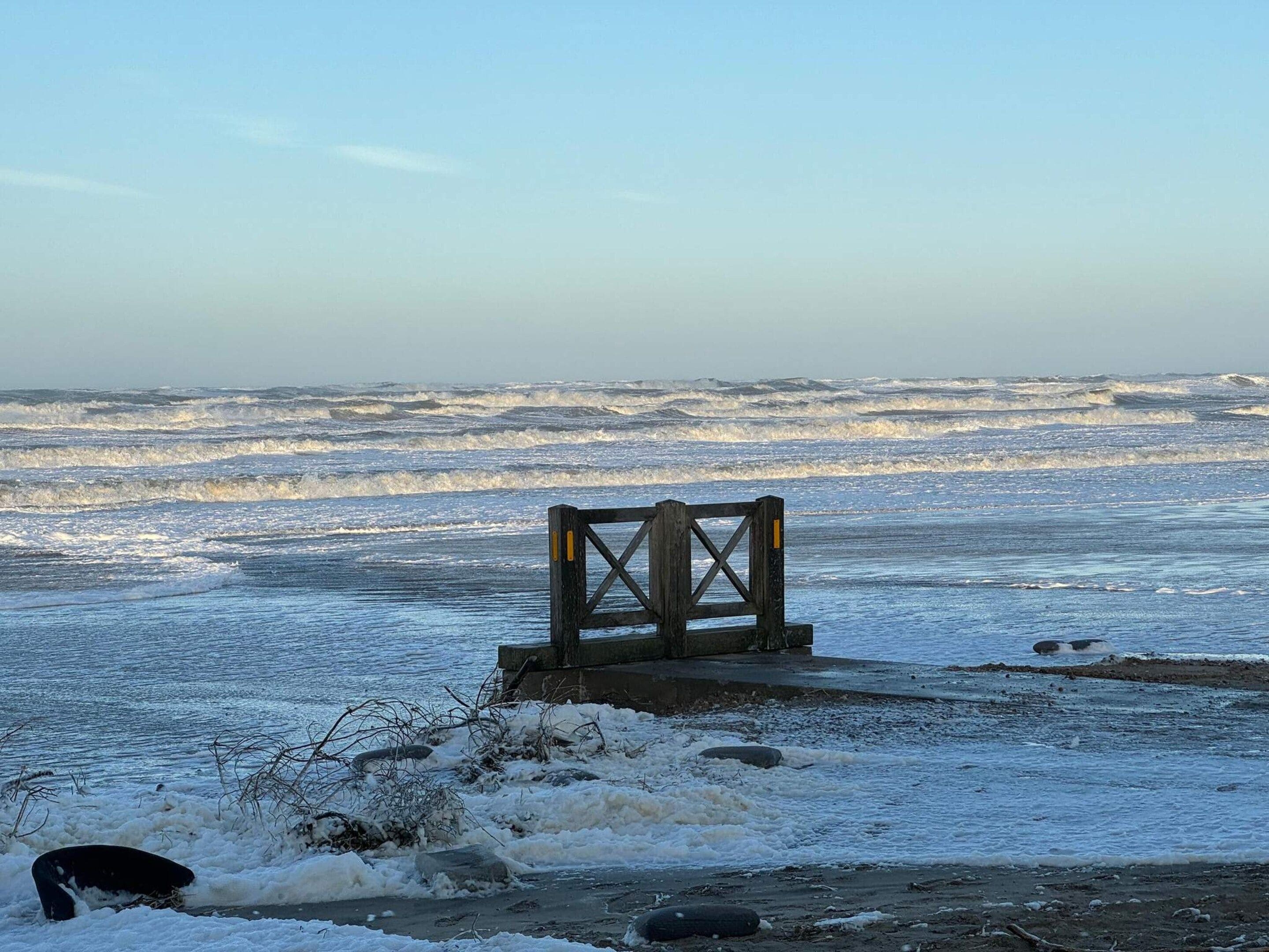 Une structure en bois surmontée d’une croix, construite sur une étendue d’eau gelée.