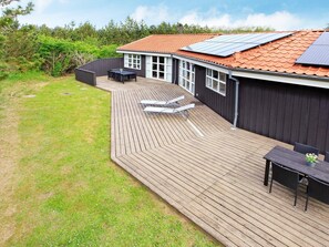 A deck with a curved roof, outdoor furniture, and solar panels.