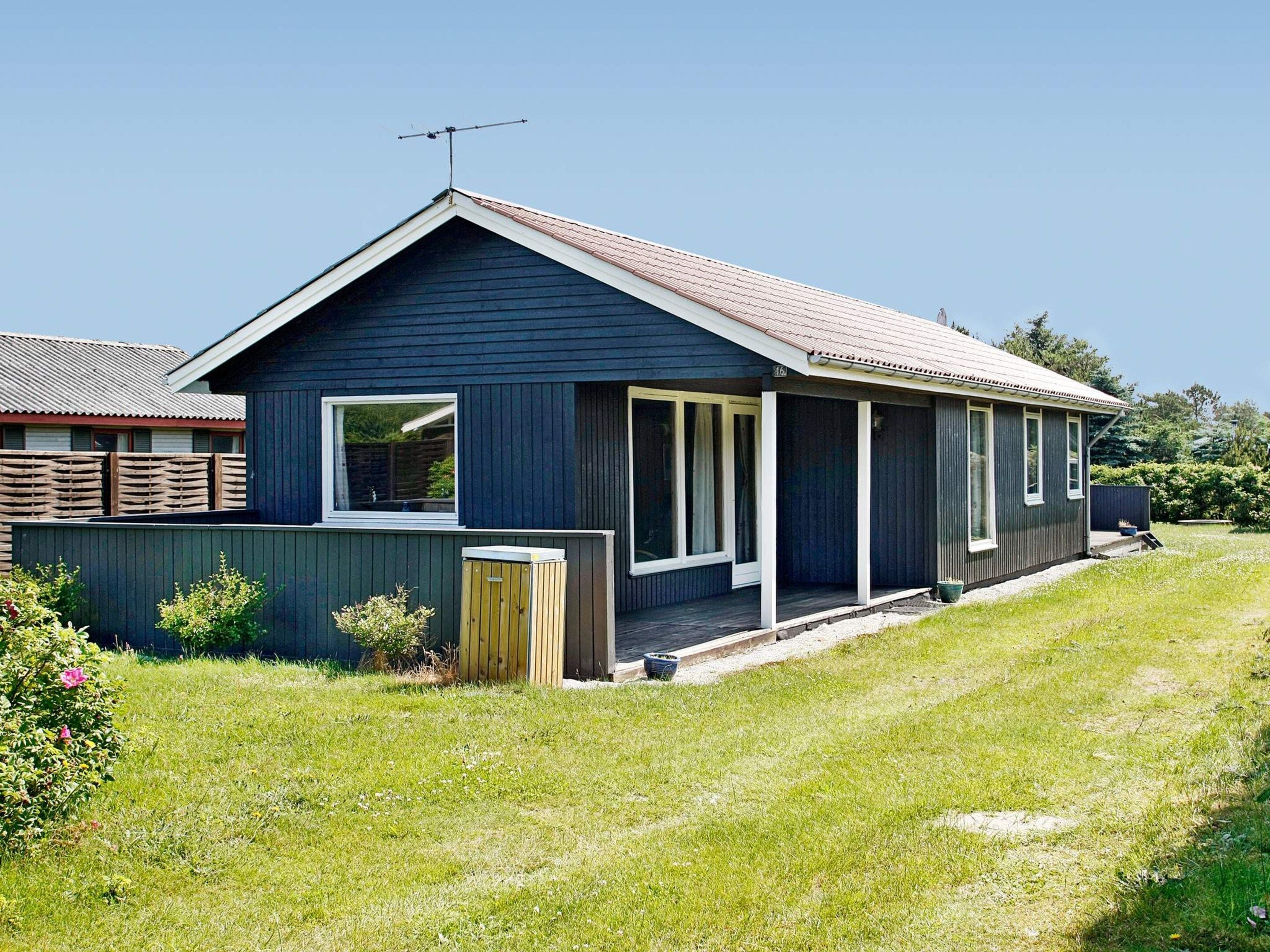 Eenlaags huis met schuine kap, een zichtbare schoorsteen en een omheind erf.