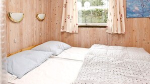 A room with a bed, two wall-mounted lamps, a window with curtains, and two framed pictures on the wall. - 6 Person Holiday Home in Lokken-by Traum (Lokken)