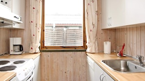 A compact kitchen with a stove, coffee maker, and sink. - 6 Person Holiday Home in Lokken-by Traum (Lokken)