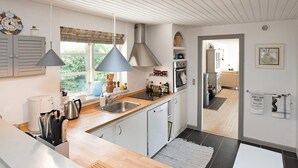 A modern kitchen with wooden countertops, stainless steel appliances, and pendant lighting. - 5 Person Holiday Home in Vejby-by Traum (Vejby)