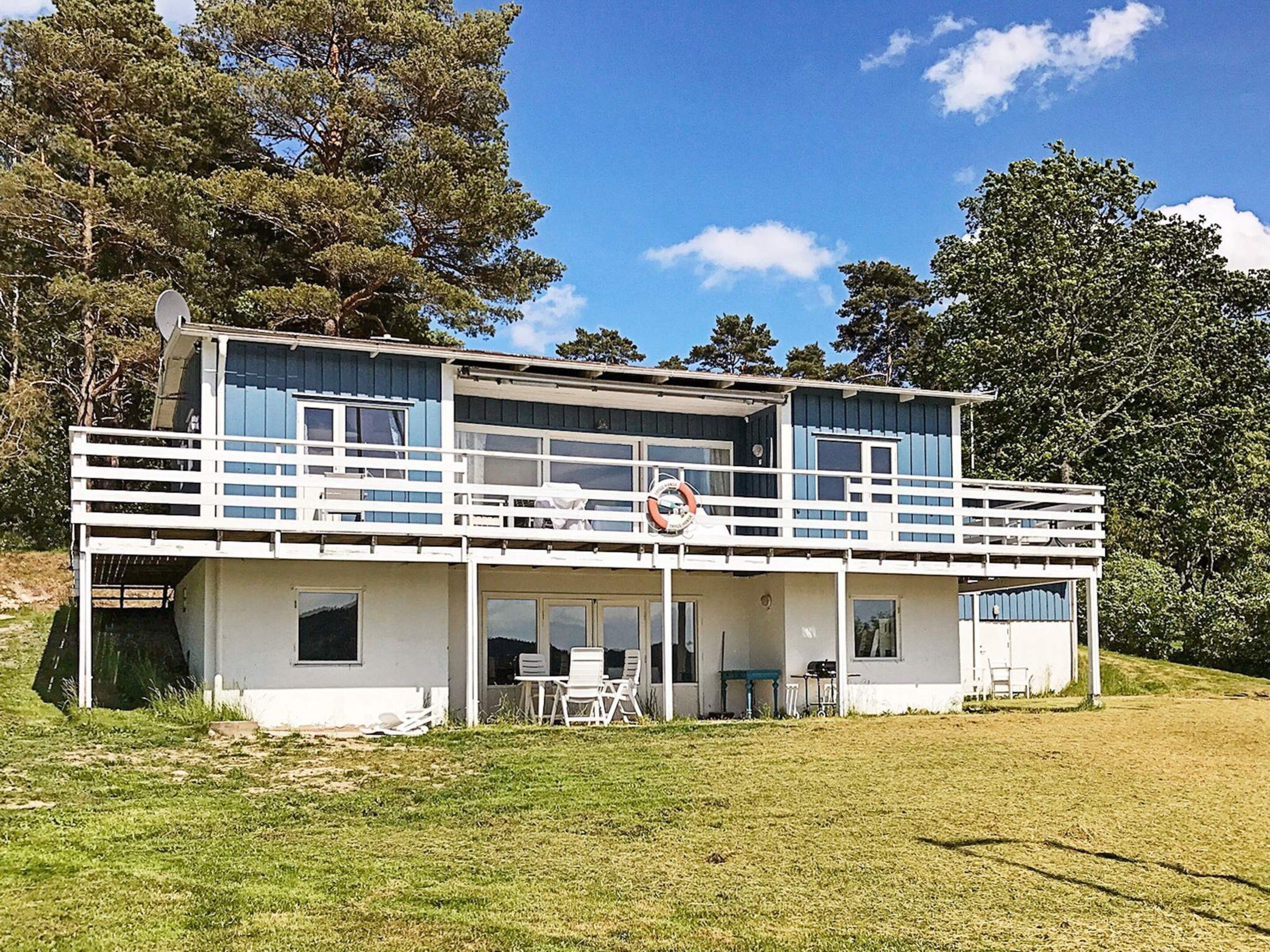 A two-story building with a balcony, outdoor seating, and a lifebuoy.