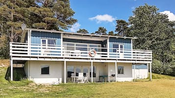 A two-story building with a balcony, outdoor seating, and a lifebuoy.