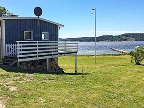 A wooden building with a balcony, a flagpole, and a view of a lake.