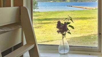 A window with a view of a lake and a grassy field.