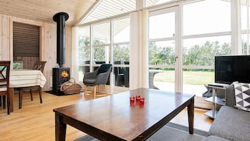 En hyggelig stue med pejs, spiseplads og sofa.