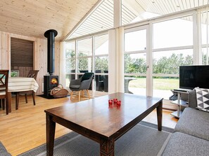 A cozy living room with a fireplace, a dining area, and a sofa.