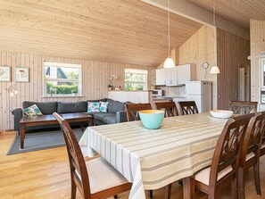 Un interior acogedor con comedor, sofá y cocina.