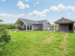 A residential property with a detached house, a garage, and a covered outdoor seating area.