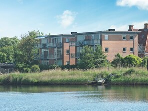 A multi-story residential building with balconies, situated next to a body of water. - 4 Star Holiday Home in Hejls (Hejls)