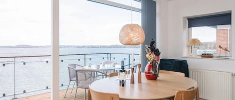 A dining area with a table, chairs, and a view of the water.