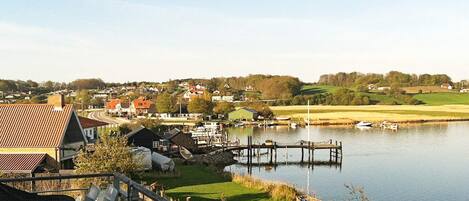 Un pueblo a orillas del lago con casas, un muelle y barcos.