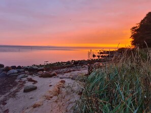 A beach with a calm sea, a clear sky, and a sunset. - 4 Star Holiday Home in Hejls (Hejls)