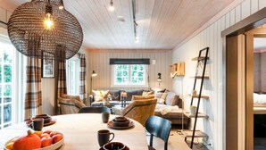 A cozy dining area with a wooden table set for a meal, surrounded by comfortable seating. - Holiday Home in FÃ¥vang (Ringebu)