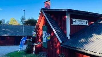 Un edificio rojo con un letrero que dice 'Wildmarks-café' y una bandera azul con un logotipo.