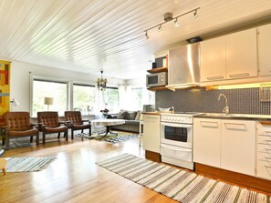 A modern kitchen with white cabinetry, a stainless steel range hood, and a microwave. - 4 Person Holiday Home in Hallabro (Hallaröd)