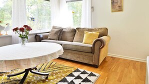 A cozy living room with a sofa, a round table, and a chandelier. - 4 Person Holiday Home in Hallabro (Hallaröd)