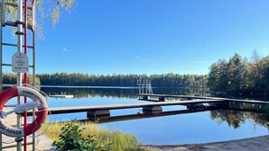 A calm lake with a wooden dock extending into the water, surrounded by trees. - 4 Person Holiday Home in Hallabro (Hallaröd)