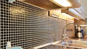 A kitchen with a black and white tiled backsplash, stainless steel appliances, and a modern faucet. - 4 Person Holiday Home in Hallabro (Hallaröd)
