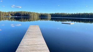 A wooden pier extending into a calm lake with a forested shoreline in the background. - 4 Person Holiday Home in Hallabro (Hallaröd)