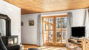 A cozy living room with a fireplace, a television, and a wooden ceiling. - 4 Star Holiday Home in Jerup (Jerup)