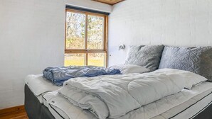A bedroom with a bed, a window, and a wooden ceiling. - 4 Star Holiday Home in Jerup (Jerup)