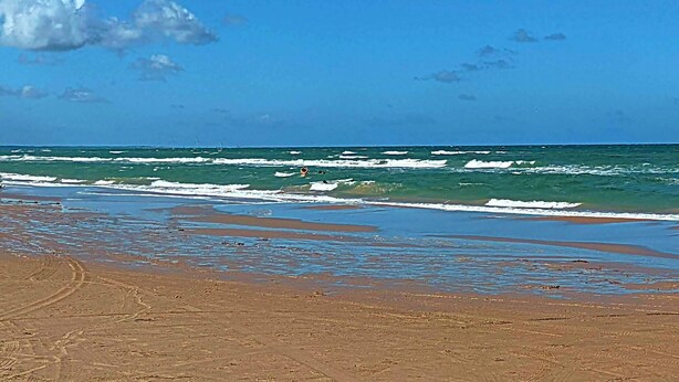 A beach with waves, clear sky, and distant boats. - 4 Star Holiday Home in Jerup (Jerup)