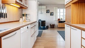 Una cucina con mobili in legno, una macchina da caffè e un piano cottura nero.