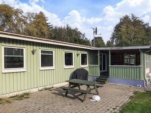 Un bâtiment écologique doté d’un espace extérieur aménagé et couvert, ainsi que d’une antenne parabolique.