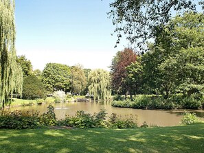 A serene park with a pond, lush greenery, and trees. - Holiday Home in GrÃ¶mmitz (Groemitz)