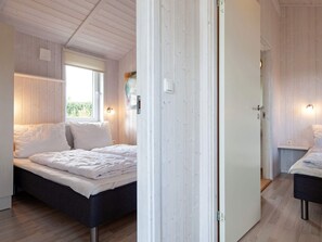Un dormitorio con una cama, una ventana y una puerta.