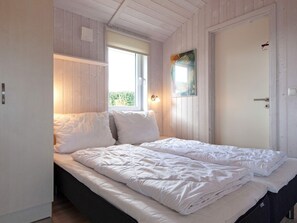 A room with a bed, a window, and a door. - Holiday Home in GrÃ¶mmitz (Groemitz)