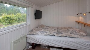 A small room with a bed, a radiator, a window, and a mounted TV. - Peaceful Holiday Home in Falster near Sea (Vaeggerlose)
