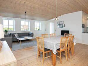 A spacious living area with a sofa, dining table, and chairs, wooden flooring, and large windows. - Spacious Holiday Home in Faaborg near Coast (Faaborg)