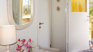 Un baño con un lavamanos blanco, un espejo y un florero con flores.