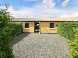 A building with a gravel driveway, two windows, and a door.