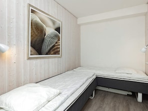 A bedroom with a bed, a bedside lamp, and a framed picture on the wall.