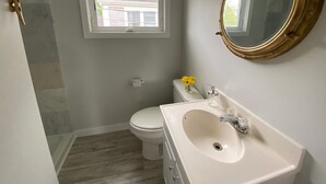 A bathroom with a toilet, sink, and mirror.