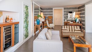A living room with a sofa, coffee table, and a wine rack.