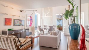 A modern living room with a sofa, chairs, a coffee table, and artwork on the walls.